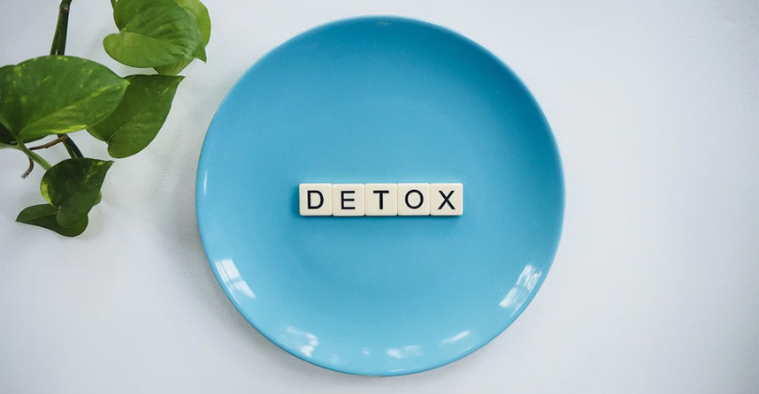 Imagem com um pratinho azul no centro e com letras formando a palavra detox.